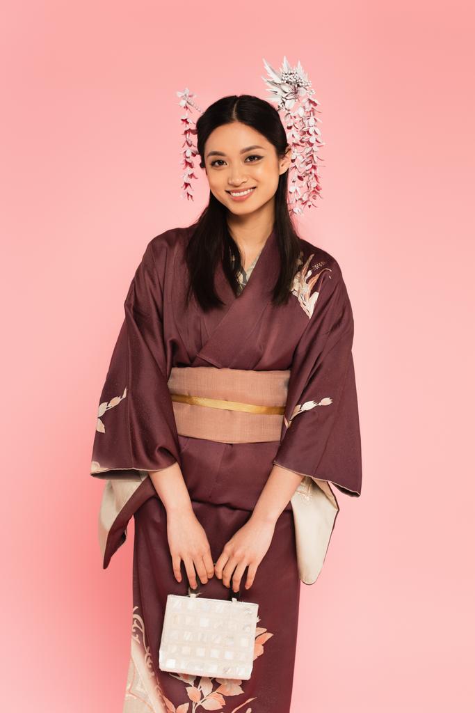 正アジアの女性で着物を保持ハンドバッグピンクに隔離  - 写真・画像