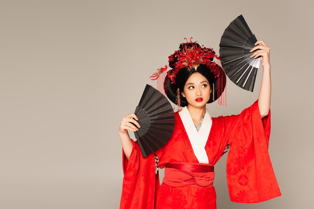 灰色に隔離されたファンを保持している東洋の服の日本人女性  - 写真・画像