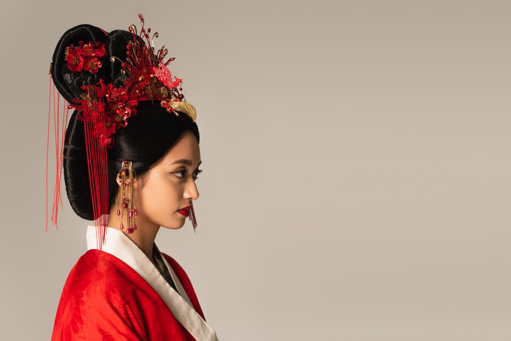 Vista lateral da mulher japonesa com penteado tradicional isolado em cinza  - Foto, Imagem