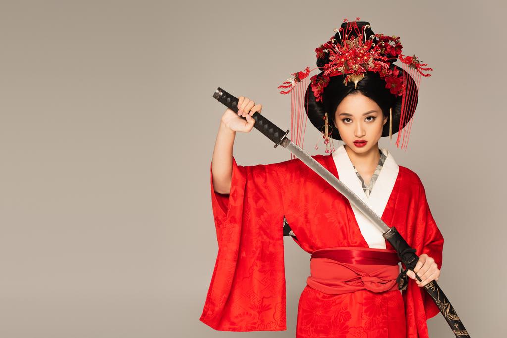 Ázsiai nő vesz kardot hüvelyből elszigetelt szürke  - Fotó, kép