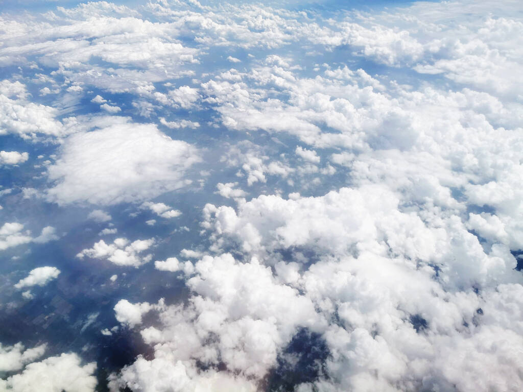 Μια μαγευτική θέα από ψηλά πυκνά χνουδωτά σύννεφα στον γαλάζιο ουρανό - ιδανικό για ταπετσαρίες - Φωτογραφία, εικόνα