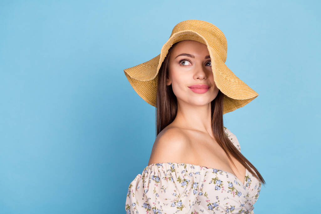 Photo de profil de cool cheveux bruns jeune dame regarder espace vide porter chapeau robe florale isolé sur fond de couleur bleue - Photo, image
