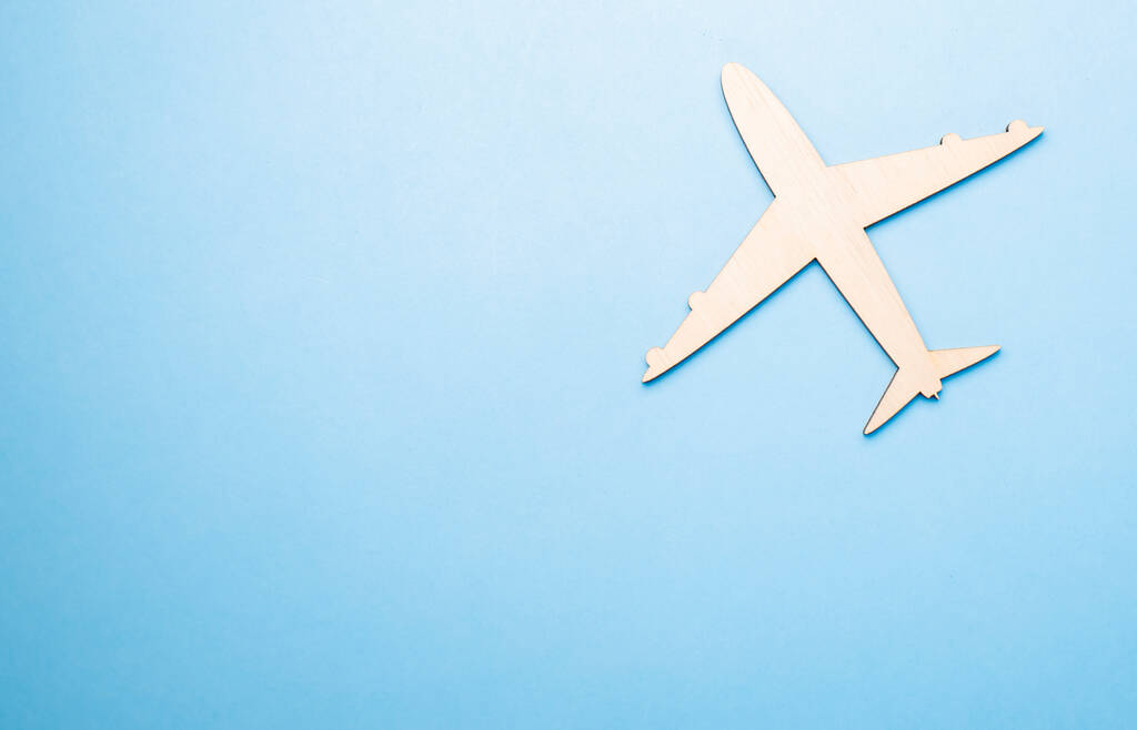 Модель іграшкового літака білого кольору на синьому фоні з місцем для додавання тексту, концепцією повітряного транспорту, туризму, подорожей
. - Фото, зображення