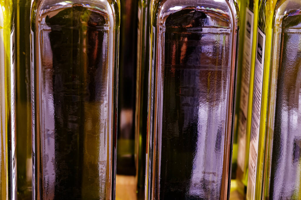 Botellas llenas de aceite se sientan en el estante - Foto, imagen