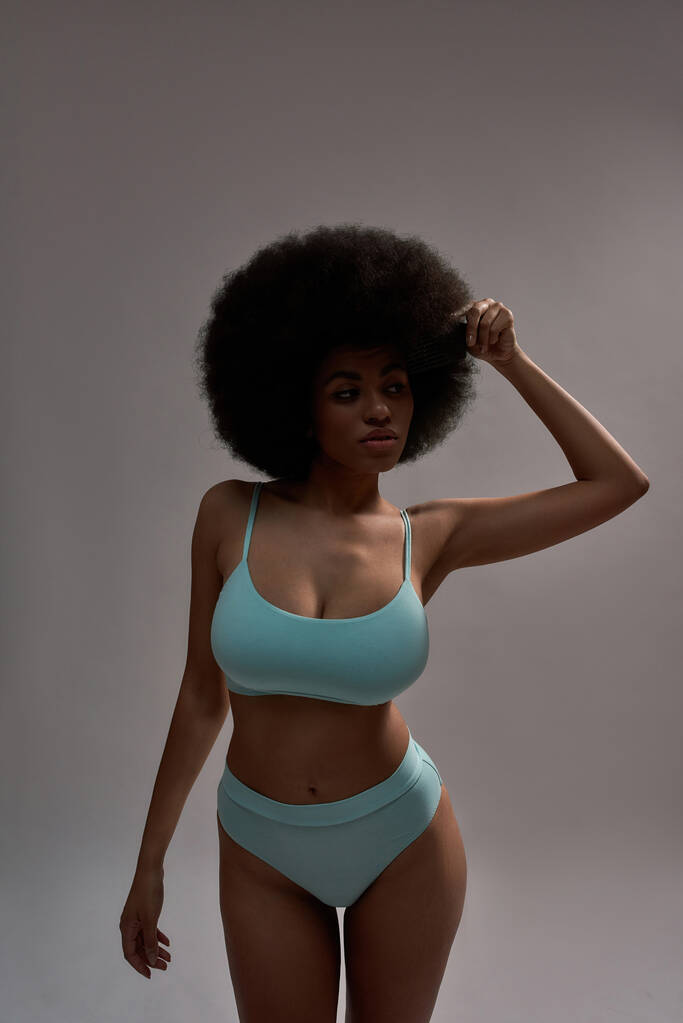 Jeune femme afro-américaine avec la main sur la coiffure afro - Photo, image
