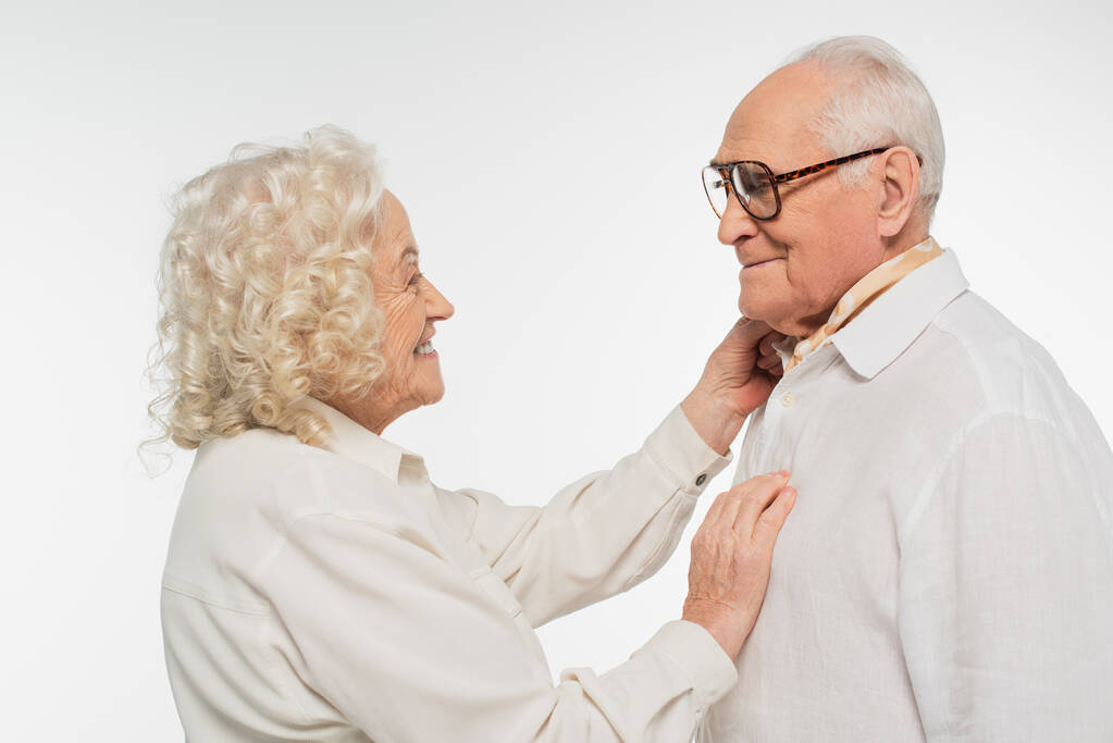anciana tocando suavemente al hombre mayor con la mano aislada en blanco - Foto, imagen