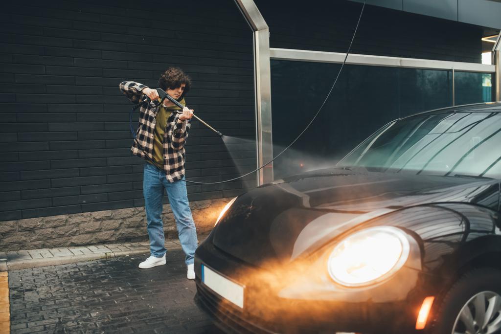 Lockiger Fahrer wäscht Auto auf Selbstbedienungswaschanlage  - Foto, Bild