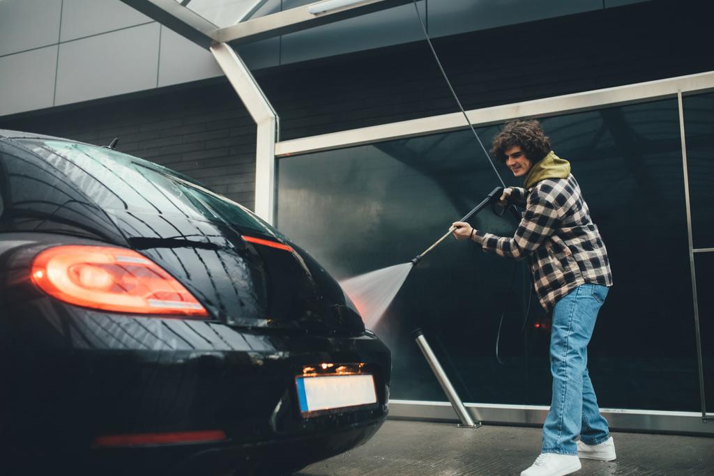 Usmívající se muž s tlakovou myčkou čištění auto na self service mytí - Fotografie, Obrázek