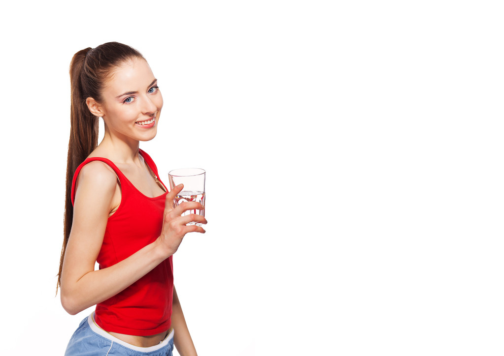 onnellinen terve urheilullinen nainen lasillisella vettä. eristetty valkoisella
 - Valokuva, kuva