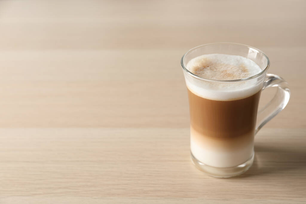 Caffè caldo con latte in tazza di vetro sul tavolo di legno. Spazio per testo - Foto, immagini