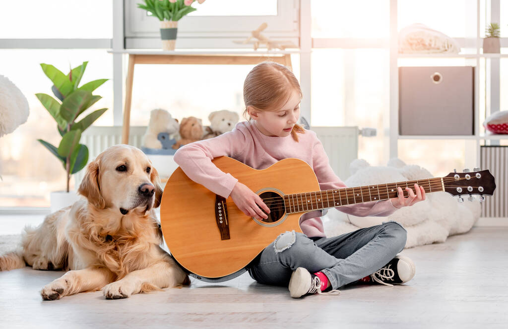 Κοριτσάκι με κιθάρα και σκύλο γκόλντεν ριτρίβερ - Φωτογραφία, εικόνα
