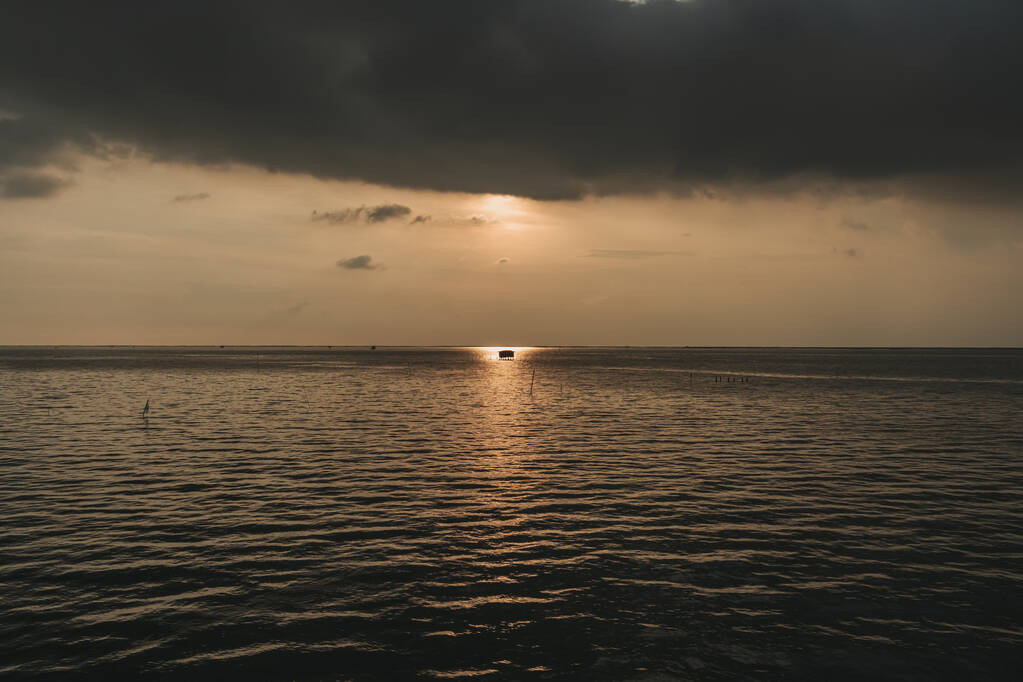 Μικρή καλύβα στη μέση του ηλιοβασιλέματος και της θάλασσας. - Φωτογραφία, εικόνα