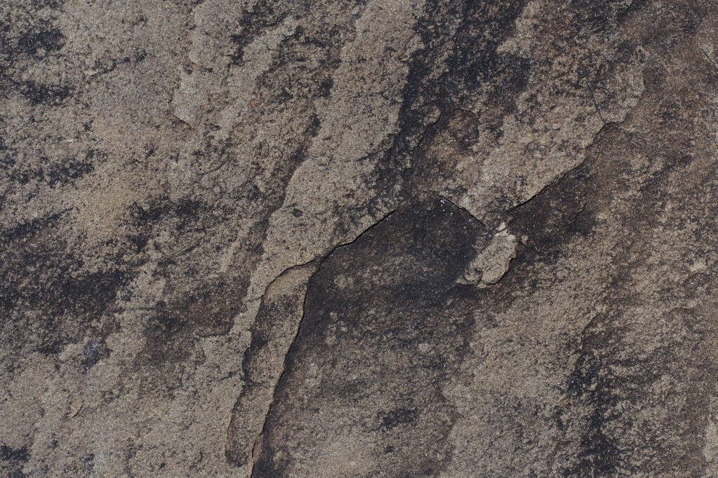 Graue und schwarze Gesteinsstruktur. Natursteinhintergrund mit Kopierraum. Rissige Oberfläche aus verwittertem Granit - Foto, Bild