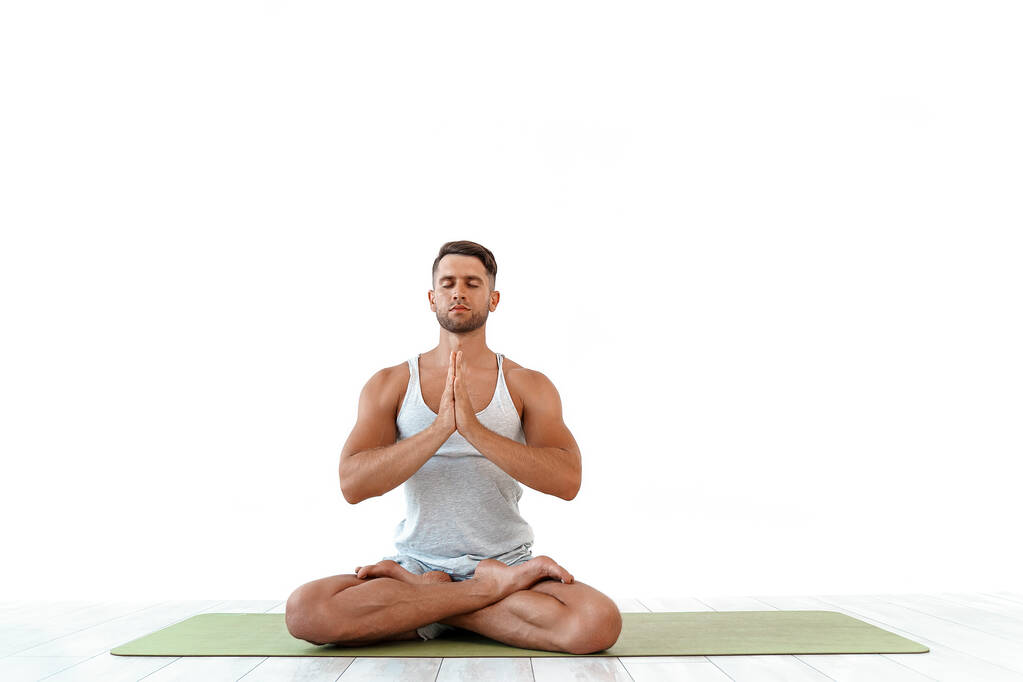 Yoga masculino madita en pose clásica en estudio sobre fondo blanco - Foto, imagen