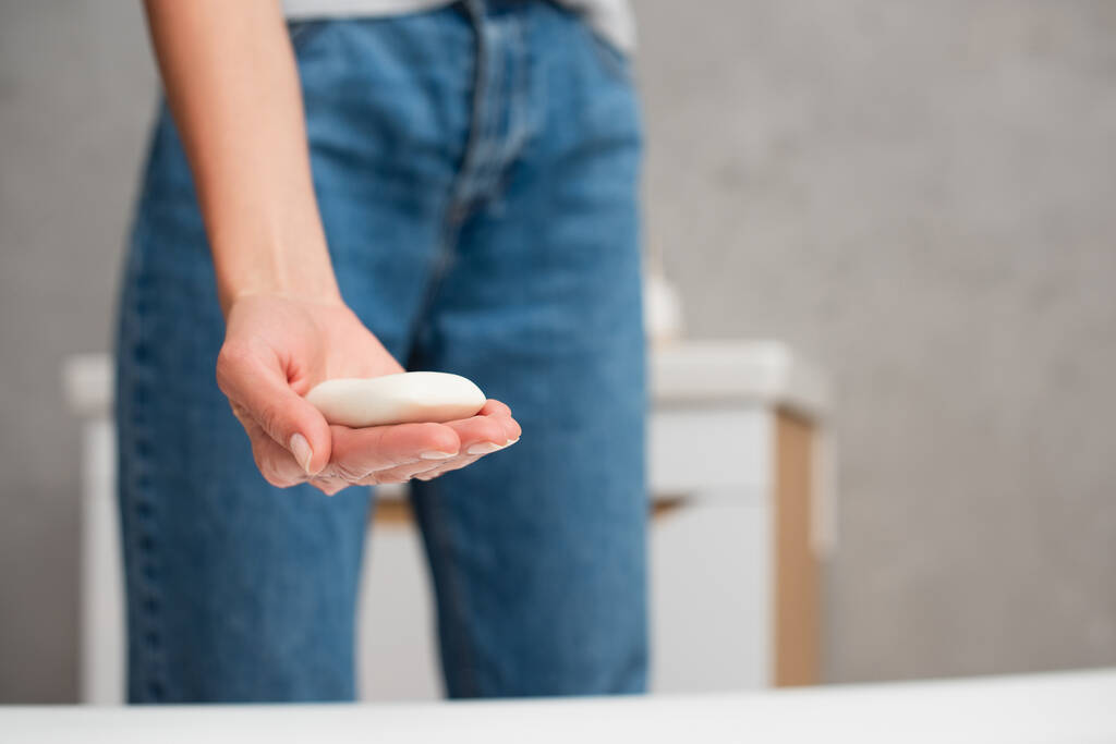 Gewassen weergave van zeep in de hand van wazige vrouw  - Foto, afbeelding