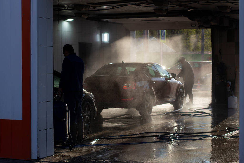Οι εργαζόμενοι πλένουν τα αυτοκίνητά τους κάτω από την πίεση του νερού. Πλύνε το αμάξι σου.. - Φωτογραφία, εικόνα