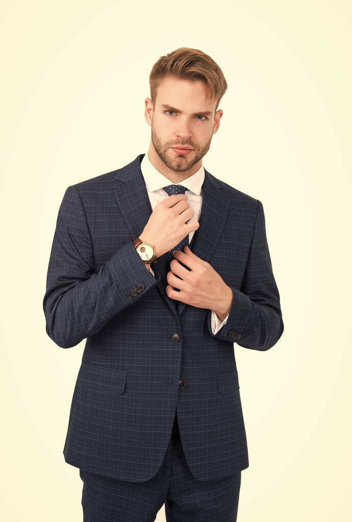 Βοηθός διευθυντής καθορίσει γραβάτα φορώντας κομψό ενταγμένο μπλε κοστούμι σε επίσημο στυλ μόδας που απομονώνονται σε λευκό, επίσημο ένδυμα - Φωτογραφία, εικόνα