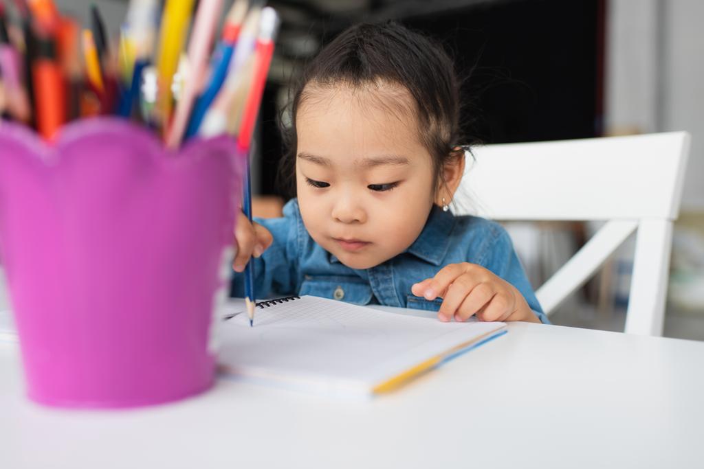 Ázsiai gyerek rajz közelében elmosódott ceruzák  - Fotó, kép