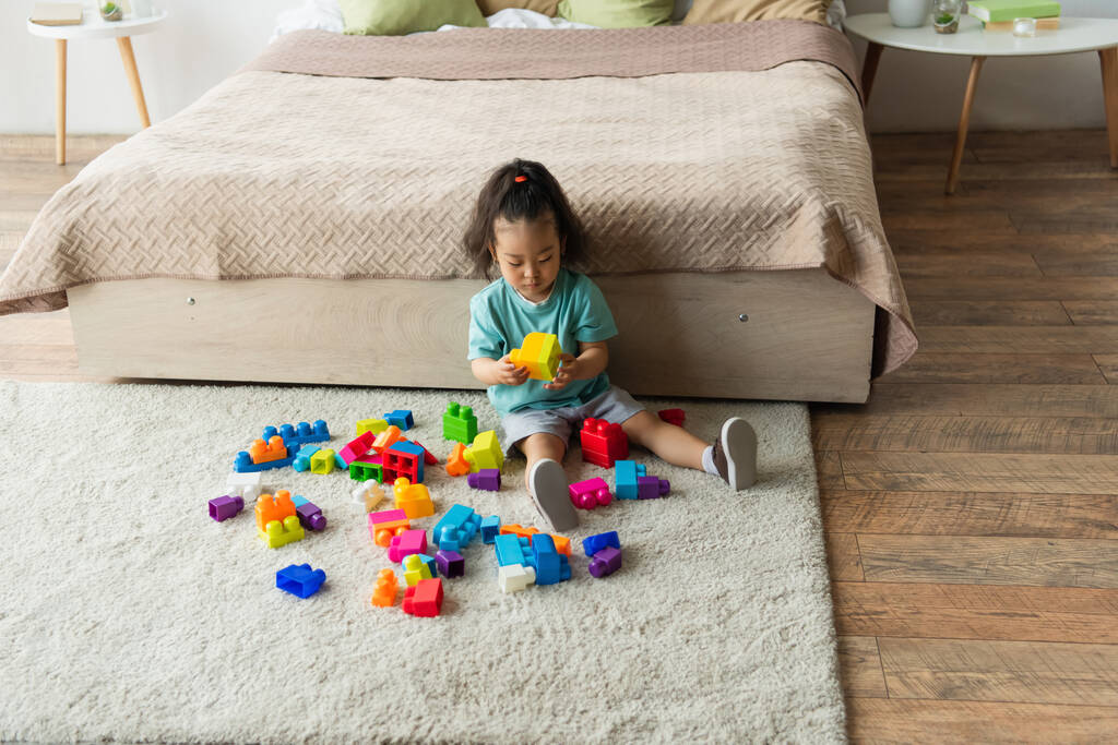 Asian toddler kid playing building blocks in bedroom  - Photo, Image