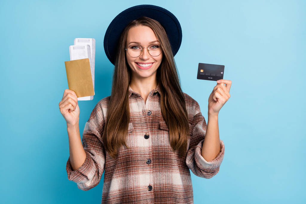 幸せな興奮笑顔の女の子の写真クレジットカードを保持し、チケットは青の色の背景に隔離された夏休みのために残して - 写真・画像