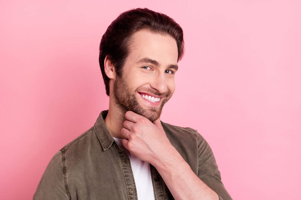 Foto de un hombre joven adorable reflexivo usar la barbilla del brazo de camisa marrón sonriendo aislado color rosa fondo - Foto, Imagen