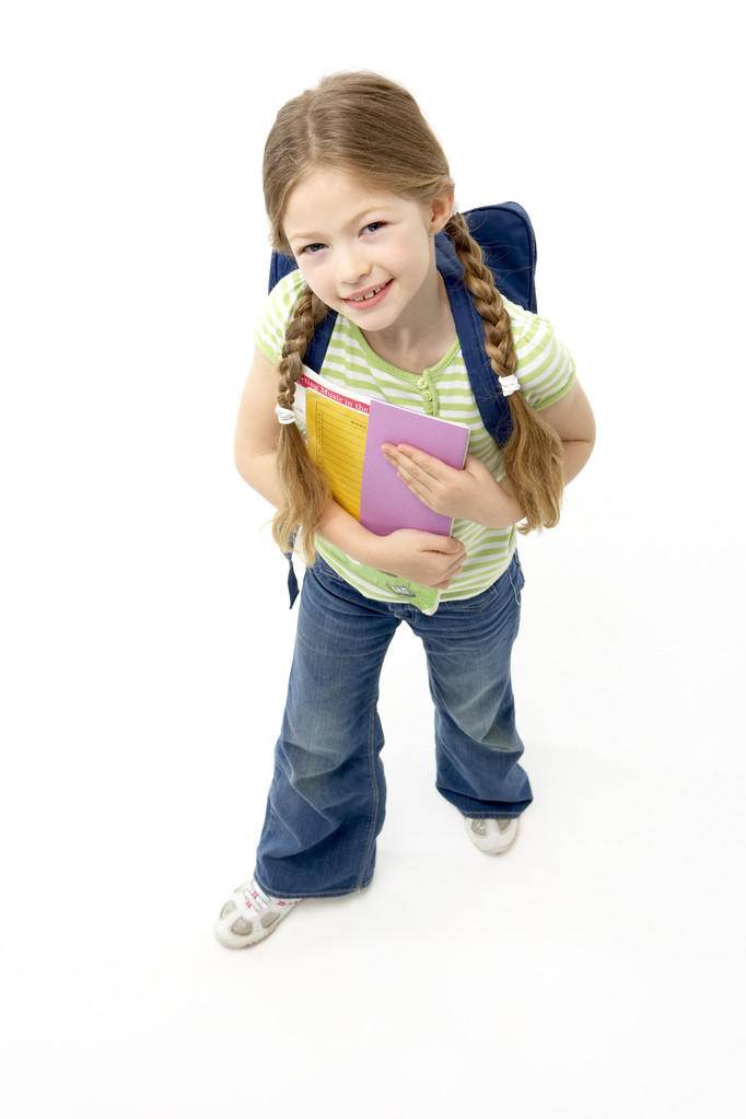 Studioporträt eines lächelnden Mädchens mit Schulbuch - Foto, Bild