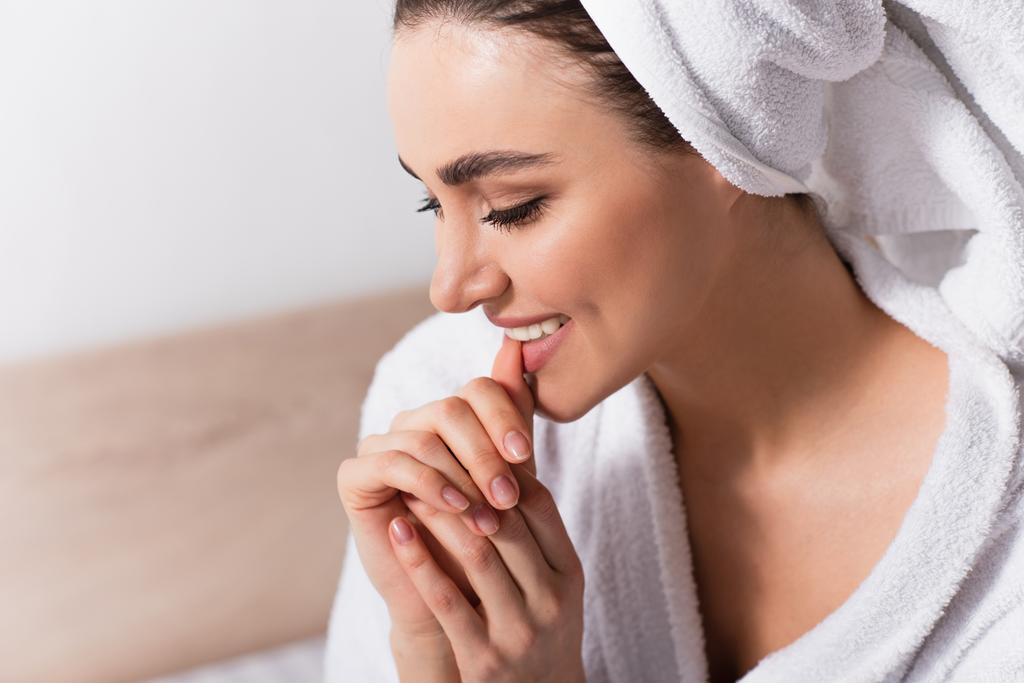 szczęśliwa kobieta w ręczniku na głowie obgryzanie paznokci - Zdjęcie, obraz