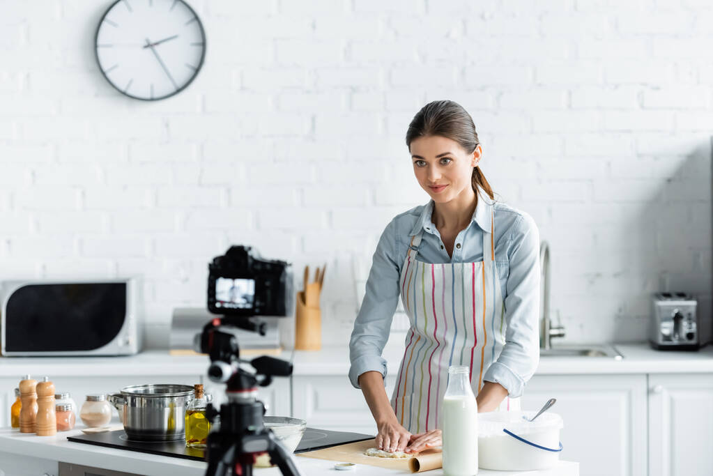 кулинарный блоггер делает тесто перед размытой цифровой камерой на кухне - Фото, изображение