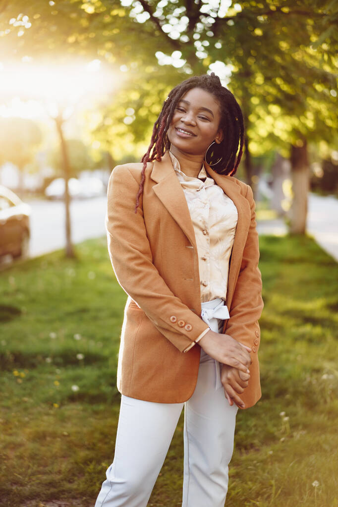 Portret van een jonge zwarte vrouw die in een straat staat - Foto, afbeelding