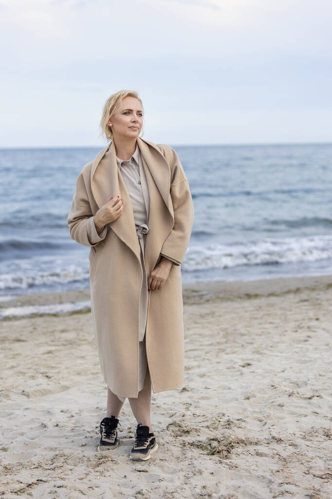 Жінка в пальто біля моря
 - Фото, зображення