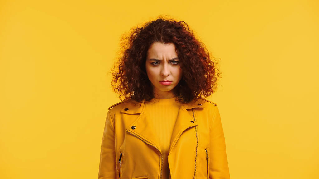 frustrovaná mladá žena v kožené bundě izolované na žluté - Fotografie, Obrázek