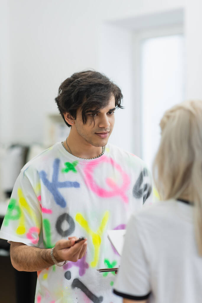 módní návrhářka mluví s rozmazaným kolegou v dílně - Fotografie, Obrázek