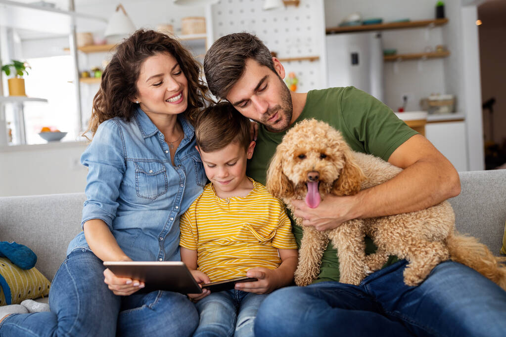 Familia feliz usando dispositivos tecnológicos juntos en casa. Personas, concepto de educación. - Foto, imagen