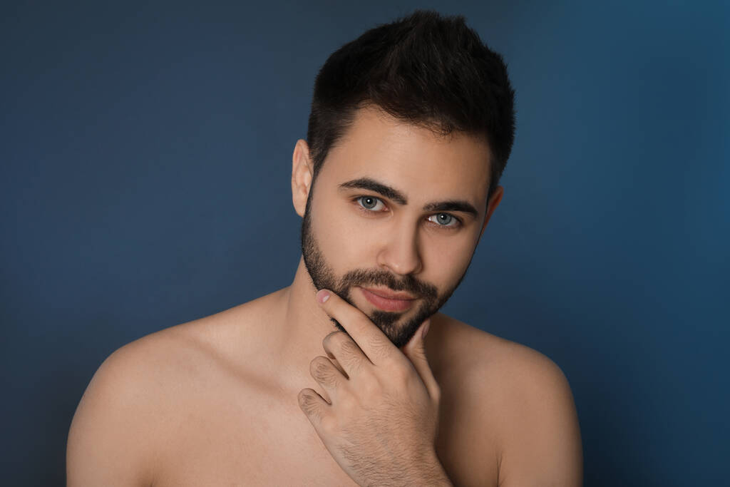 Beau jeune homme avec barbe après le rasage sur fond bleu - Photo, image