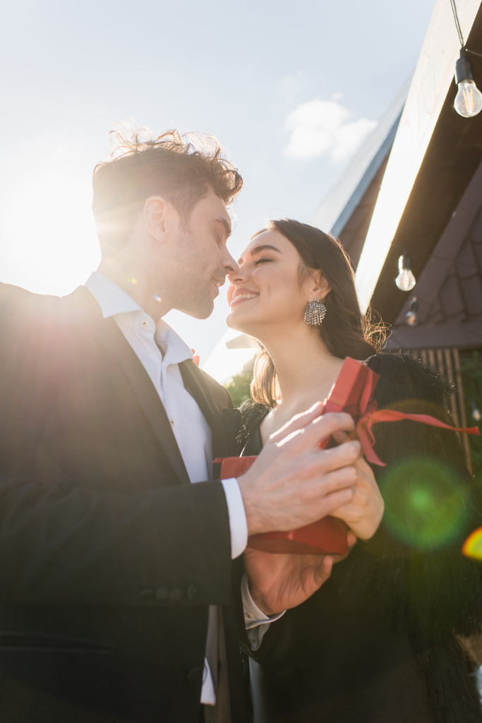 nízký úhel pohledu na šťastný pár líbání během výročí  - Fotografie, Obrázek