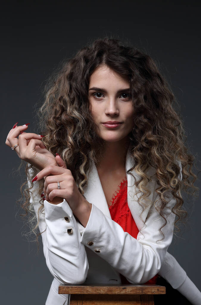 赤いブラウスと白いジャケットにハイライトの髪の美しい女の子 - 写真・画像