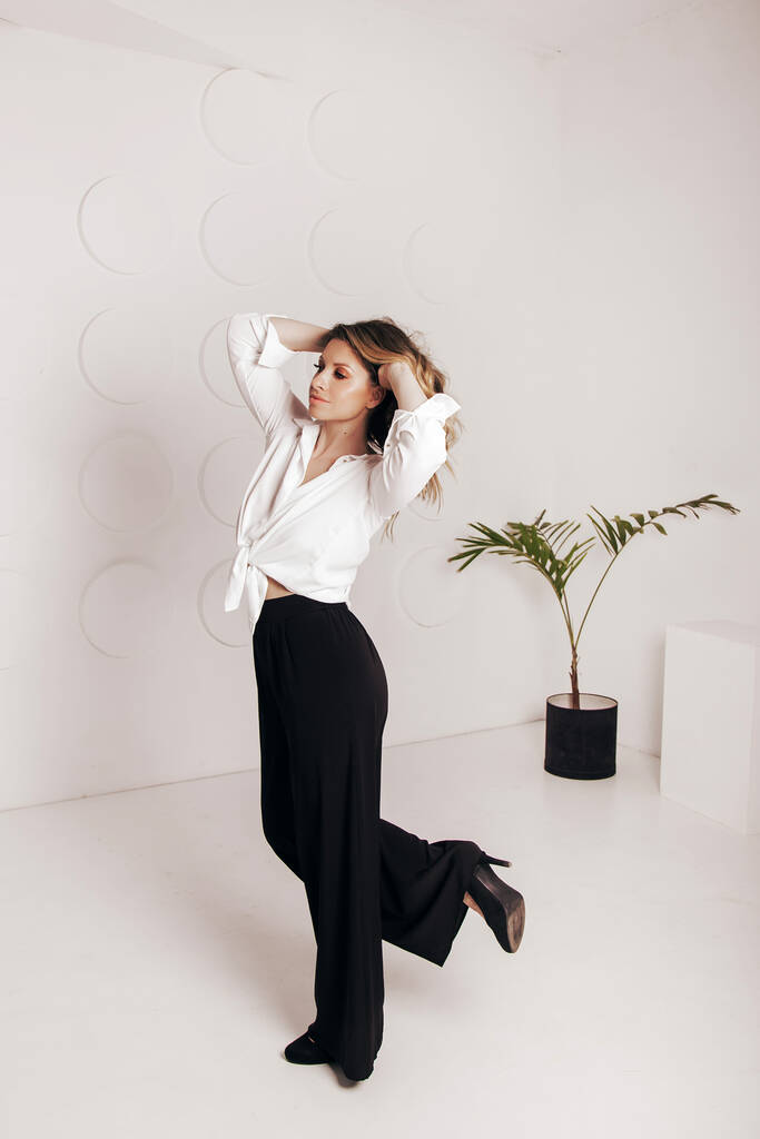Attractive sexy woman wear business look. Women look sexy and sensual. model wear white shirt and black pants. - Photo, Image