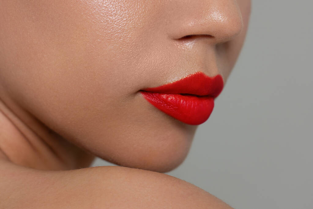 Lähikuva naisen huulet muoti kirkkaan punainen meikki. Kaunis naisen suu, täydet huulet täydellisellä meikillä. Osa naisen kasvoja. Valinta huulipuna - Valokuva, kuva