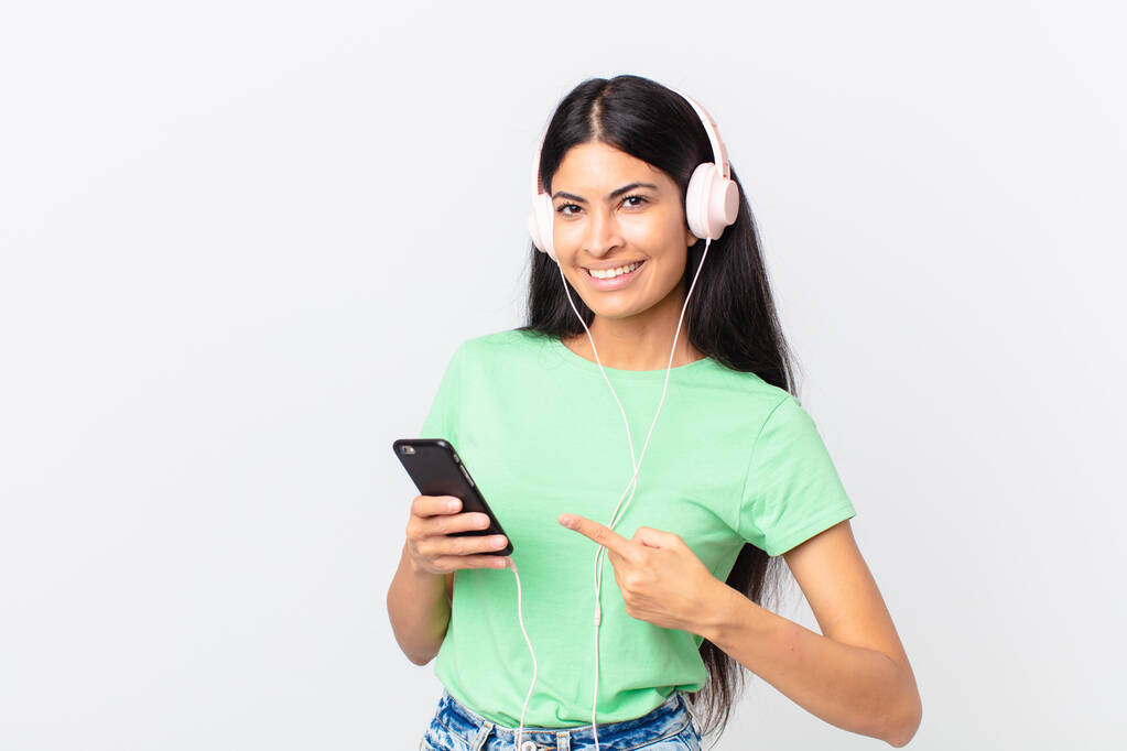 mujer bonita hispana con auriculares y un teléfono inteligente - Foto, Imagen