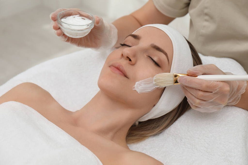 Young woman during face peeling procedure in salon - Photo, Image