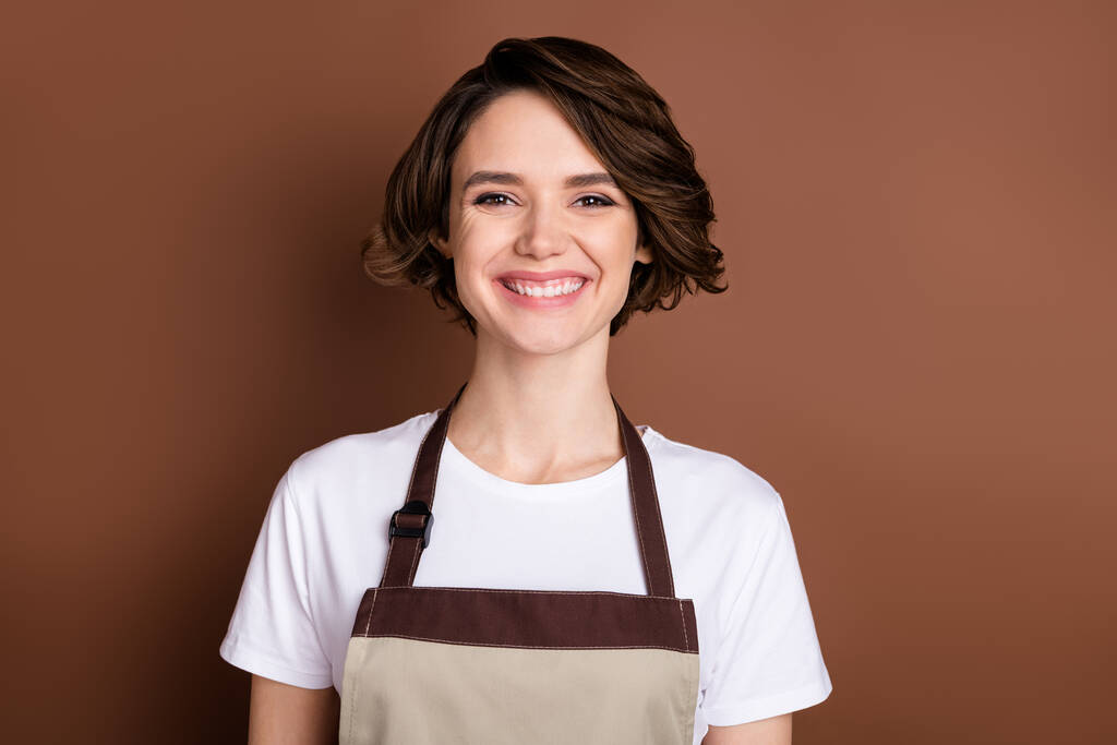 Retrato de atraente alegre menina alegre serviço ao cliente vendedor loja floral isolado sobre cor marrom fundo - Foto, Imagem