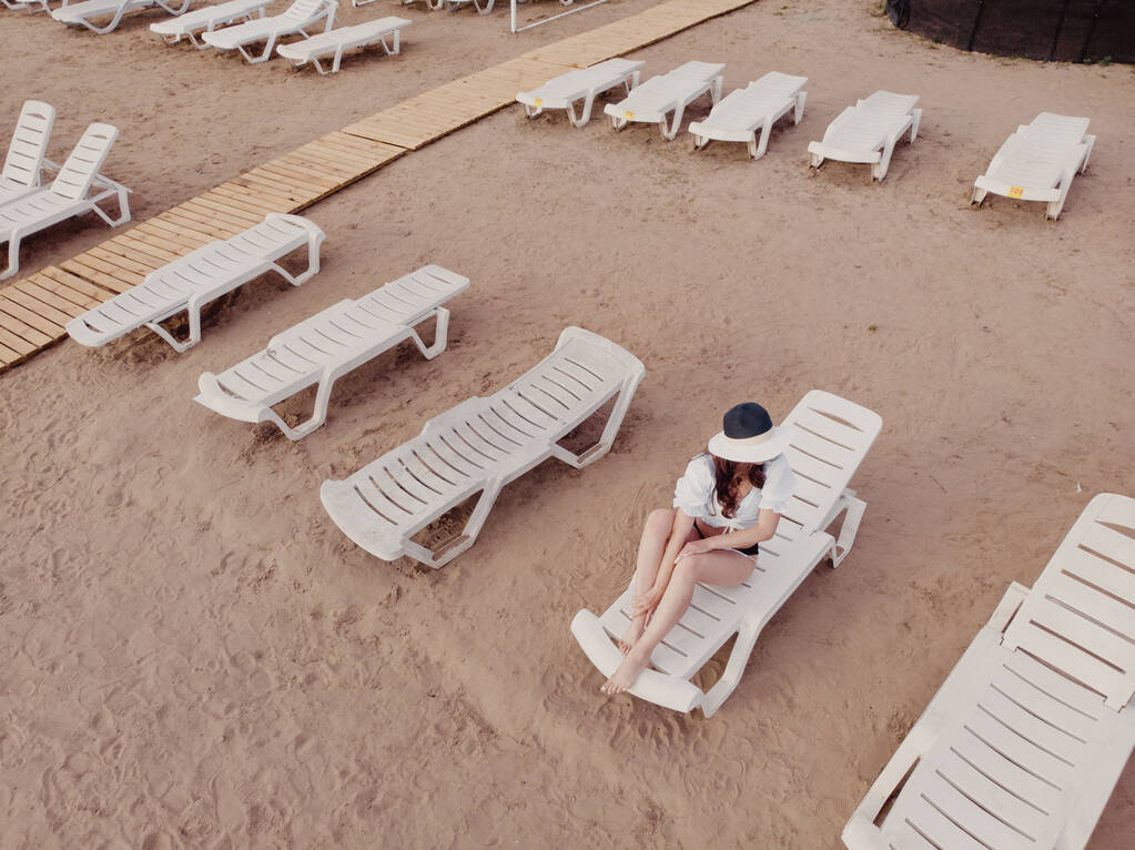 Loma ja seikkailu. Top näkymä drone rannalla, ranta tuoli ja rentoutua tyttö - Valokuva, kuva