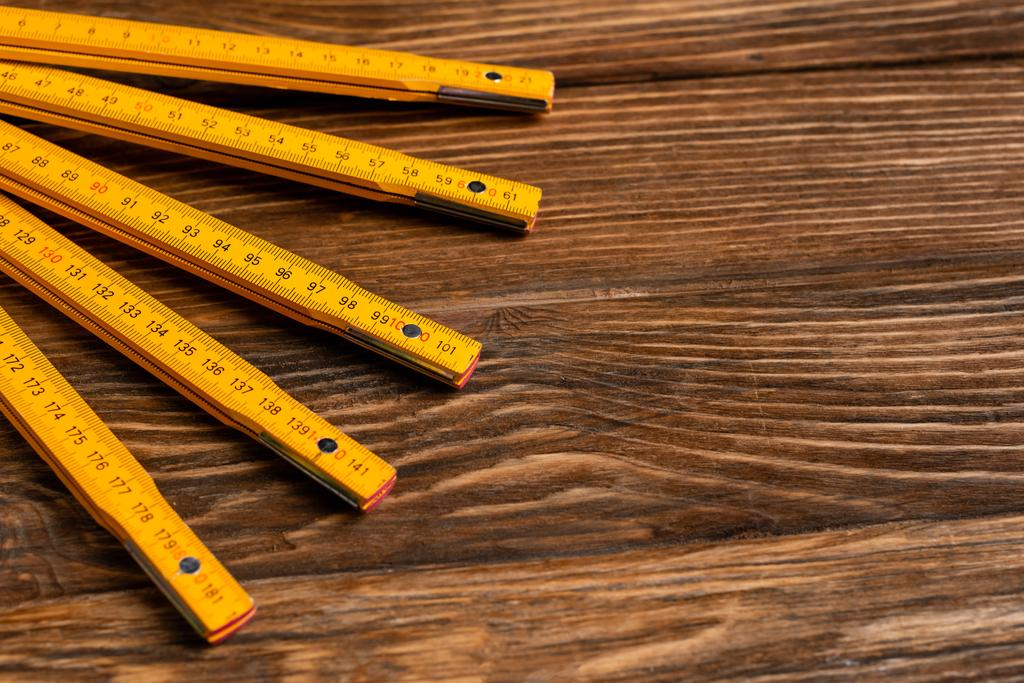 желтая складная линейка на деревянной поверхности, концепция трудового дня - Фото, изображение