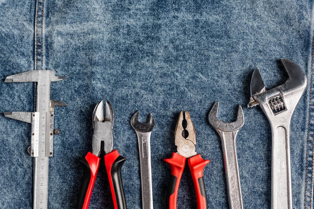 top view of different tools on blue denim cloth, labor day concept - Photo, Image