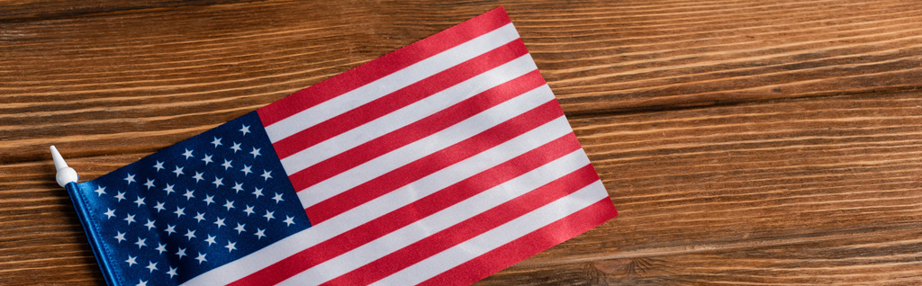 Draufsicht auf kleine amerikanische Flagge auf Holzfläche, Banner - Foto, Bild