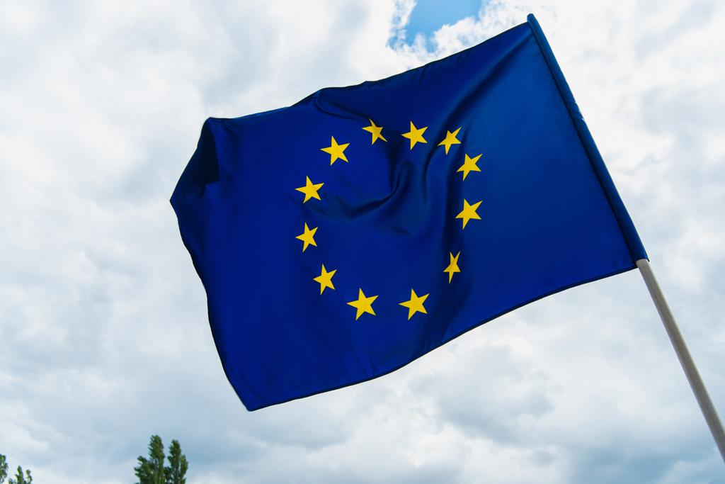 baixo ângulo de visão da bandeira da união europeia acenando contra o céu  - Foto, Imagem