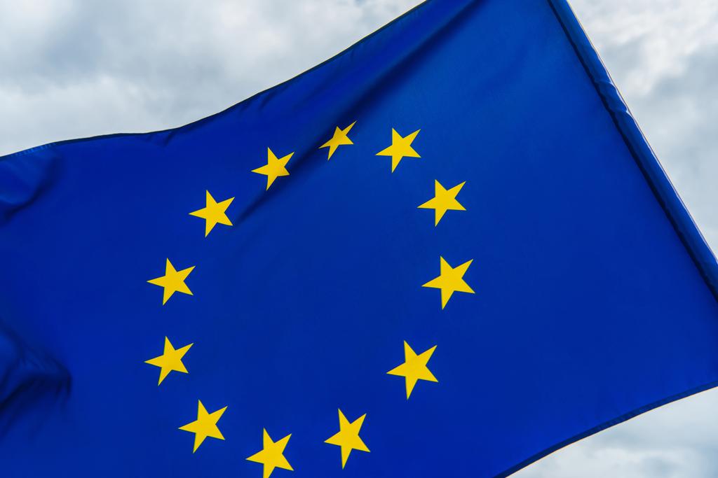 Niedrigen Winkel Ansicht der EU-Flagge gegen bewölktem Himmel  - Foto, Bild
