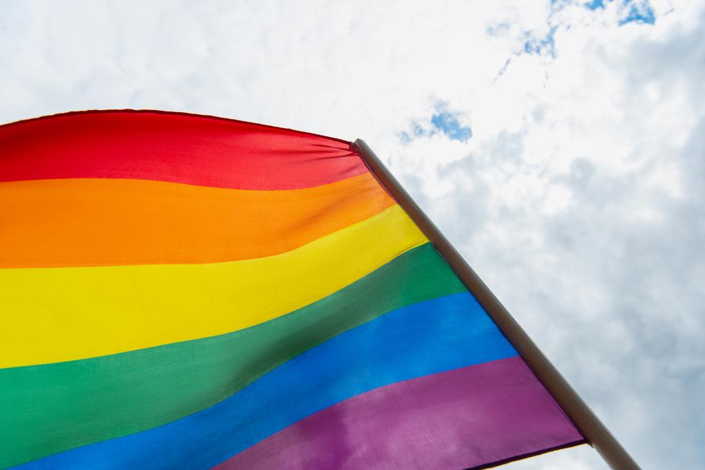 low angle view of colorful lgbt flag against cloudy sky - Photo, Image