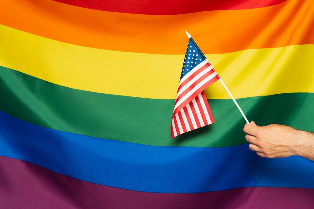 Изображение человека, держащего американский флаг на фоне цветного лака  - Фото, изображение