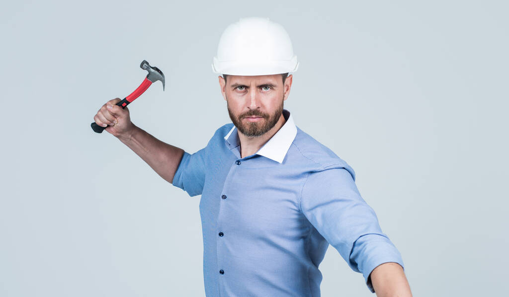 бізнес-бос з бородою і щетиною носити твердий капелюх тримає молоток, робочий день
 - Фото, зображення